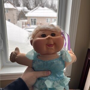 Adorable Doll with Blue Dress and Purple Ribbon